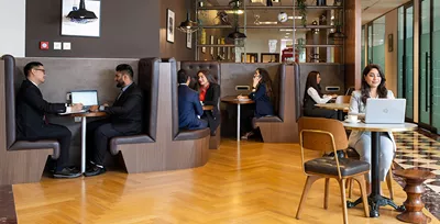 Servcorp’s vibrant coworking space at Emirates Towers, Dubai. Professionals are seen working and collaborating in a sleek, modern setting 