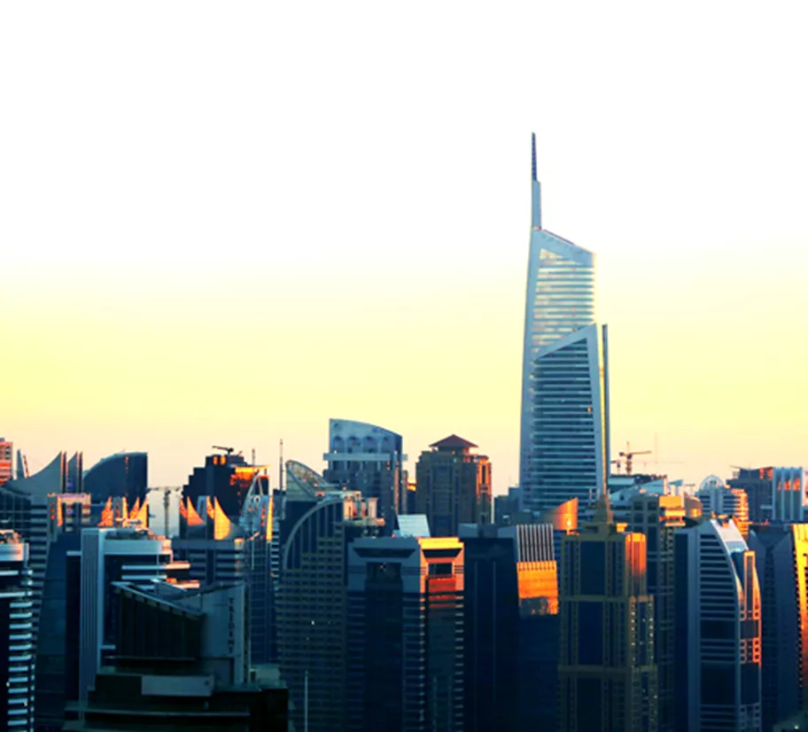 Tall modern skyscrapers at sunset, with Almas Tower standing prominently above the city skyline.