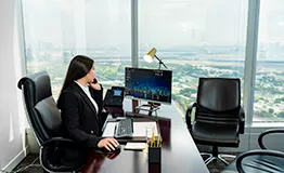 A woman is seated at a serviced office desk in Dubai, Emirates Towers
