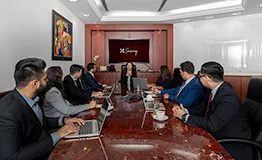 A group of individuals  seated around a large, polished conference table in an elegant Servcorp meeting room. at Emirates Towers, Dubai
